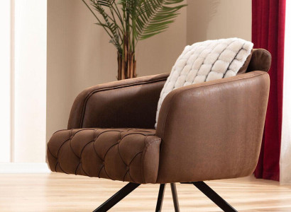 Sillón orejero tapizado individual marrón de cuero artificial.